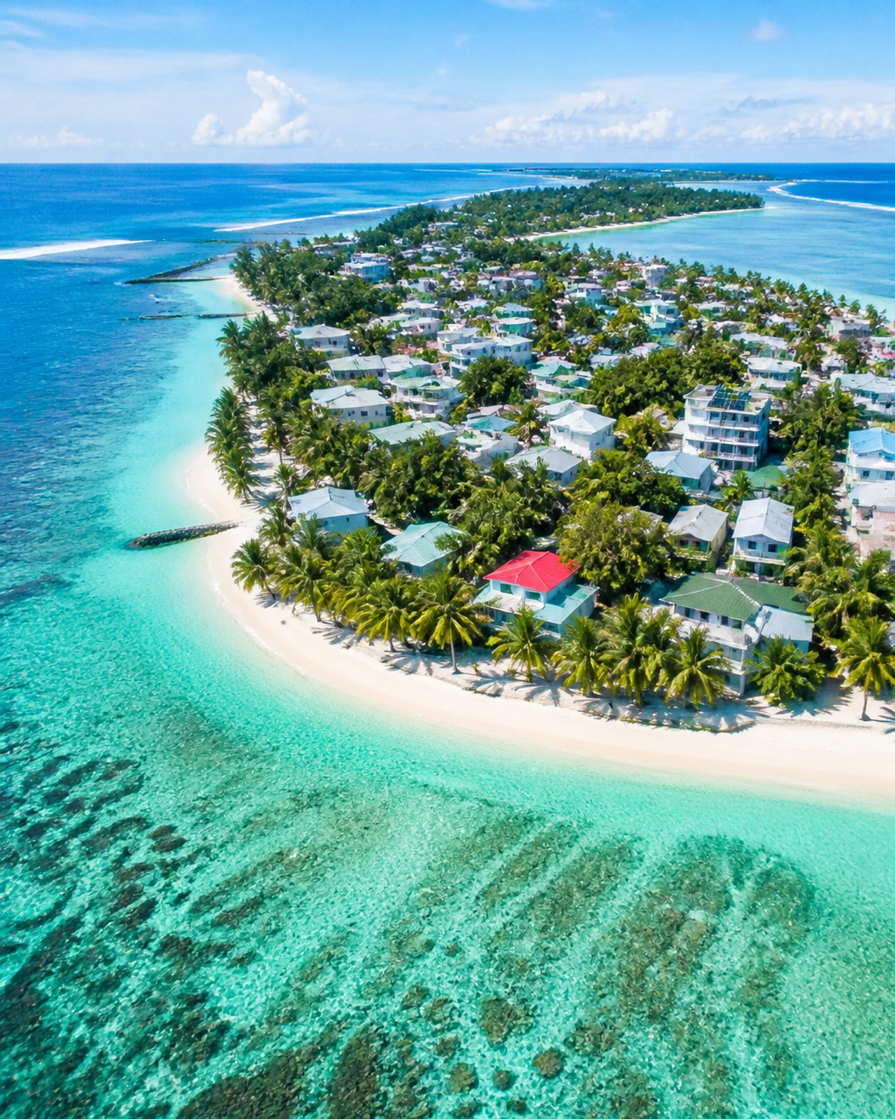 Aerial view of a Maldivian island surrounded by turquoise lagoons