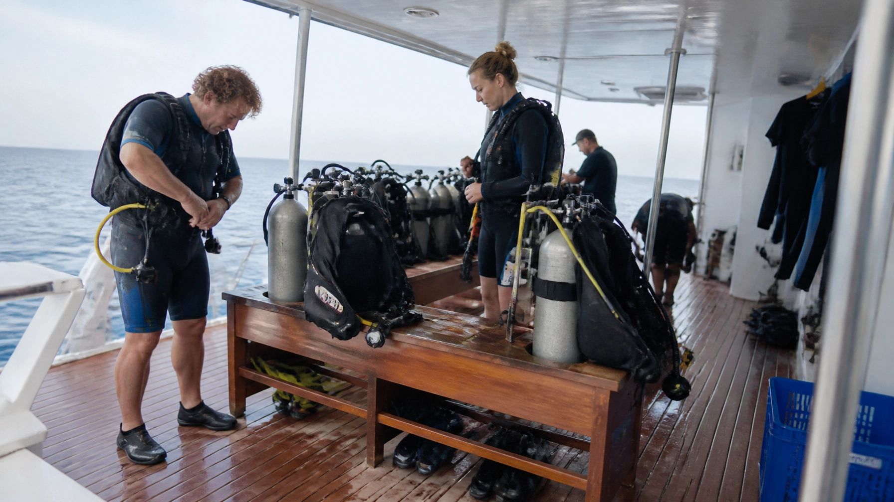 Divers gearing up on the dive deck of a luxury liveaboard yacht