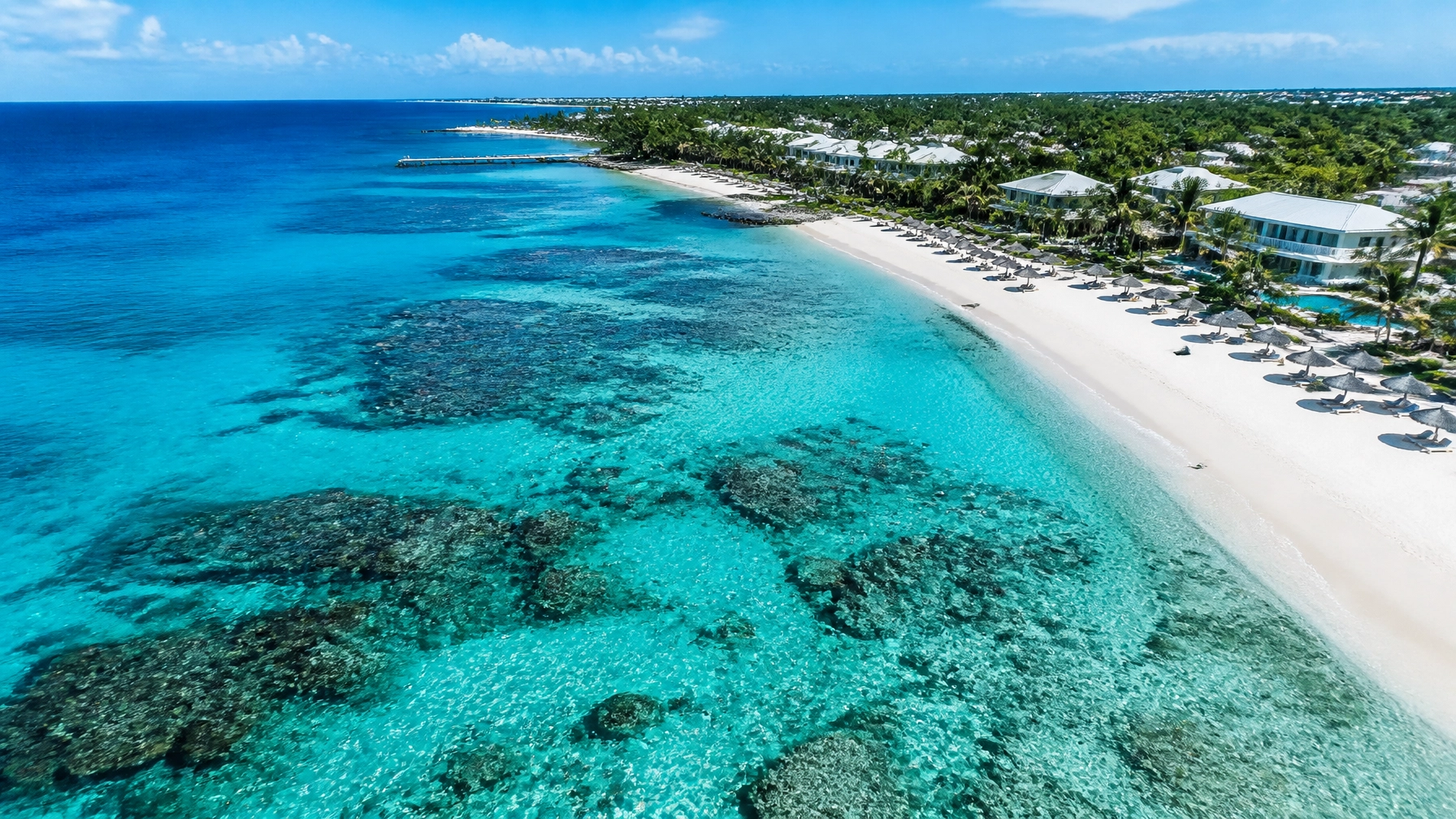 An aerial view of the stunning Cayman Islands coastline, highlighting the beauty of a destination with great travel guarantees.